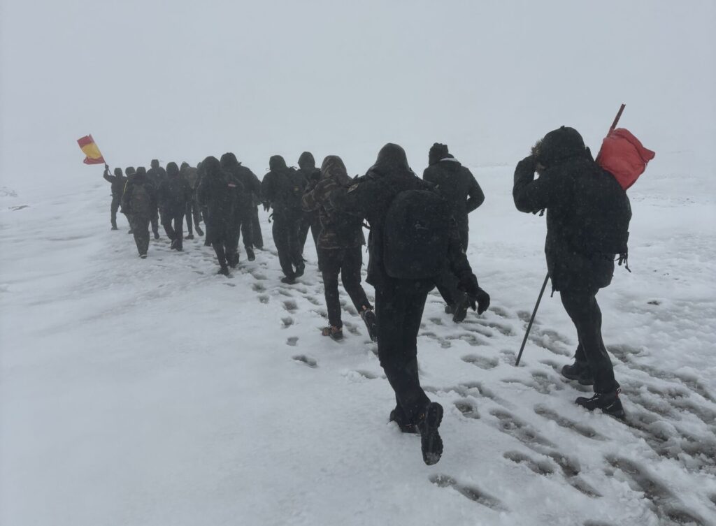 Grupo de integrantes de Facta caminando en un entorno completamente blanco por la nieve